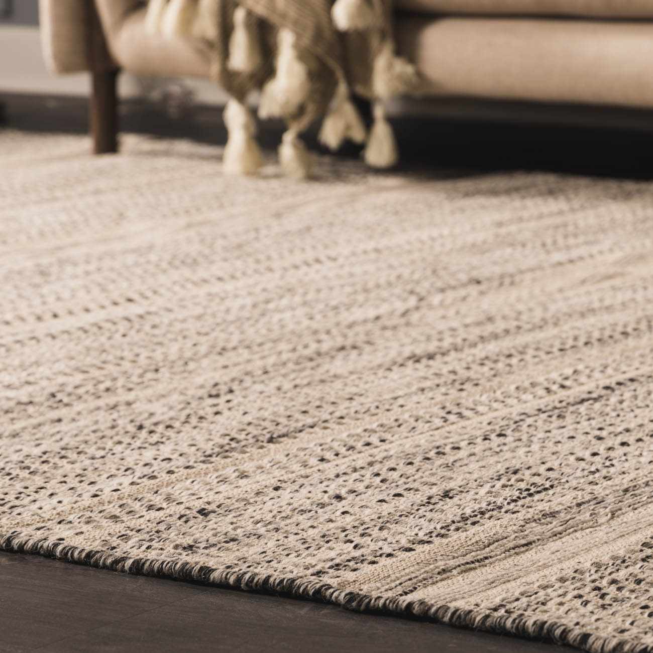 Close-up of the hand-woven Arabi Wool Area Rug in light beige and gray, with a subtle textured pattern. Roomscene-Rectangle