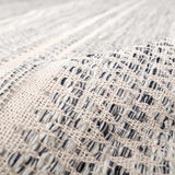 Close-up of the hand-woven Arabi Wool Area Rug, showing its black, gray, and light beige pattern and texture. Fold