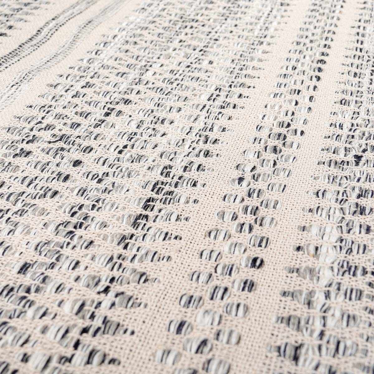 Close-up of the hand woven Arabi Wool Area Rug. Black, gray, and light beige create a textured, transitional design. Texture