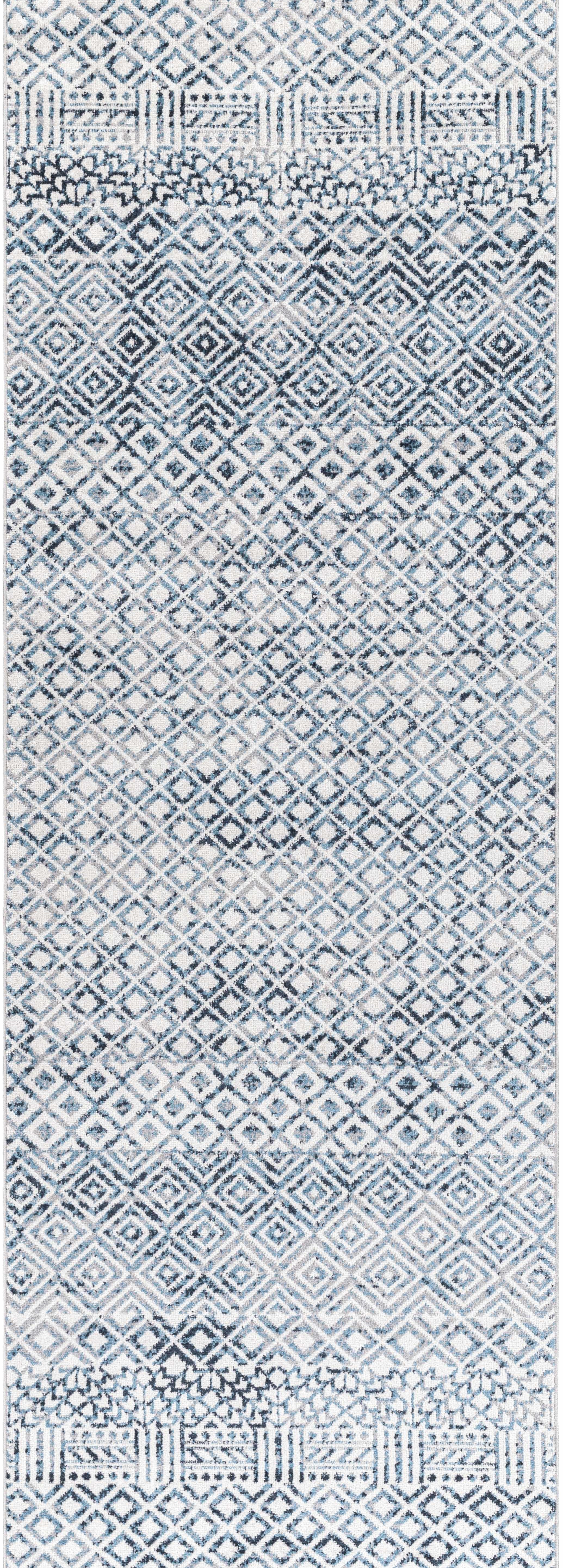 Close up of the Askeaton Washable Area Rug, featuring a geometric diamond pattern in blue, gray, and light gray hues. Design-Runner-2773