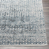 Close up of the Askeaton Washable Area Rug, showcasing its blue, gray, and white diamond pattern and soft texture. Front