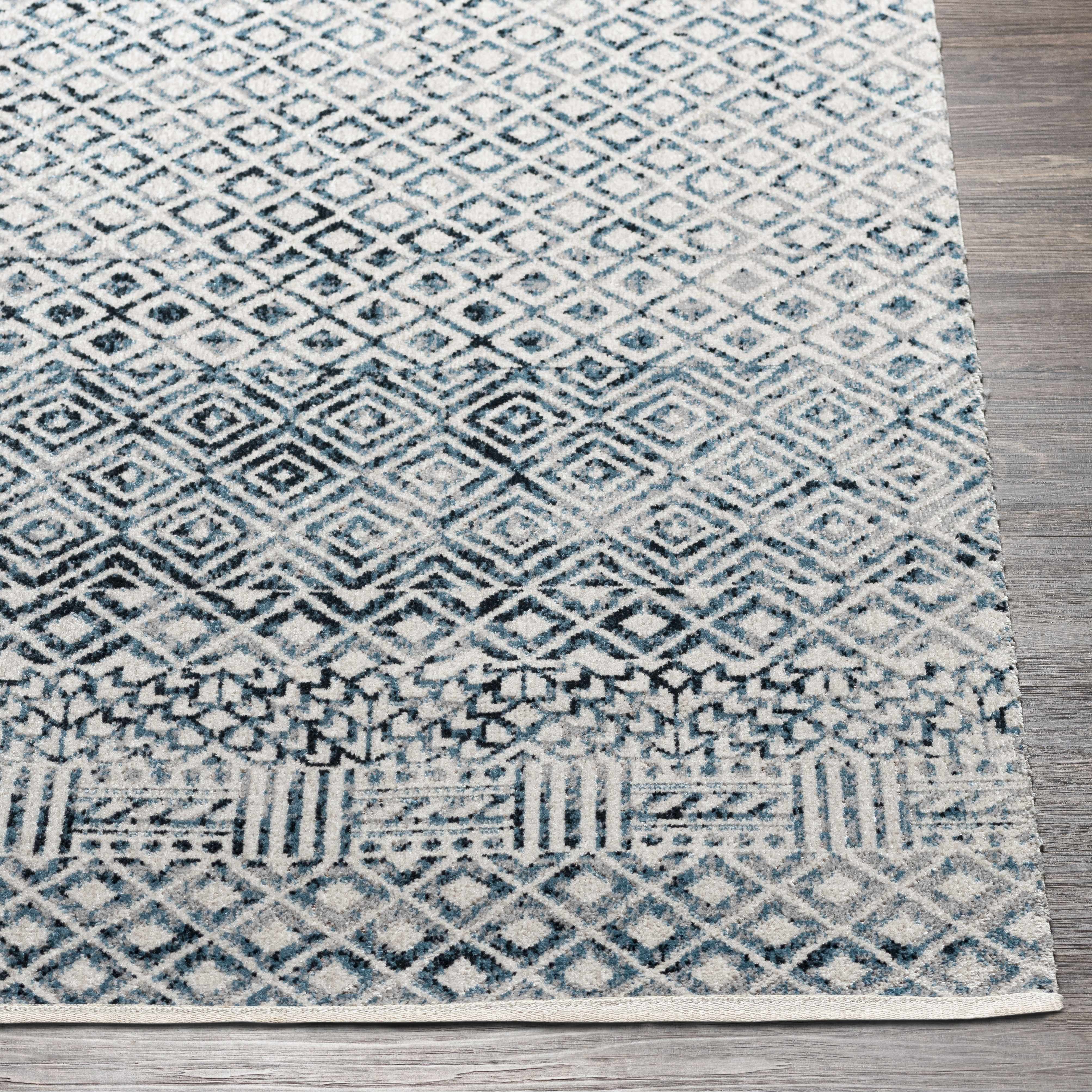 Close up of the Askeaton Washable Area Rug, showcasing its blue, gray, and white diamond pattern and soft texture. Front