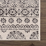 Close-up of the Warroad Area Rug. Charcoal and beige rug with a traditional, floral-inspired pattern. Swatch