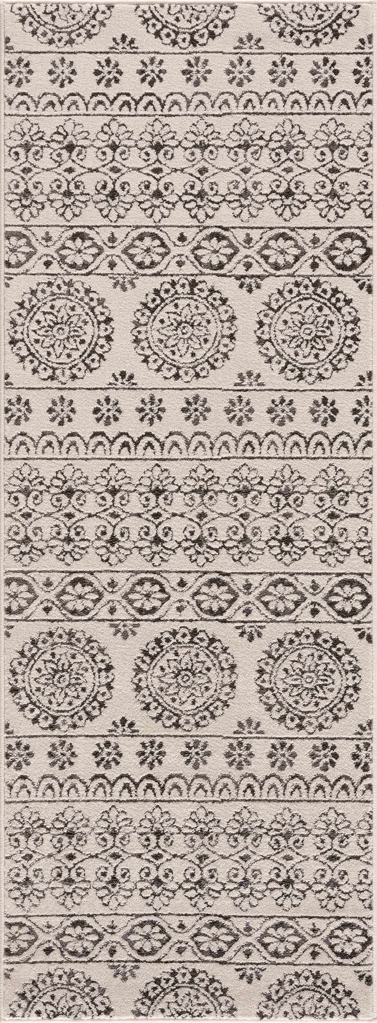 Close-up of the Warroad Area Rug. Charcoal and light beige rug with a traditional, floral-inspired pattern. Design-Runner-2773