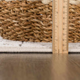 Close-up of the Warroad Area Rug showing pile height with a ruler and woven basket. Light beige color. Pile