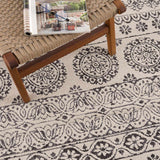 Close-up of the Warroad Area Rug, showcasing its charcoal and light beige bohemian-inspired floral medallion pattern and soft texture. Styleshot