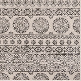 Close-up of the Warroad Area Rug. Charcoal and light beige rug with a traditional, floral-inspired pattern. Swatch