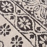 Close-up of the Warroad Area Rug showing a floral and geometric pattern in charcoal, gray, and light beige. Texture