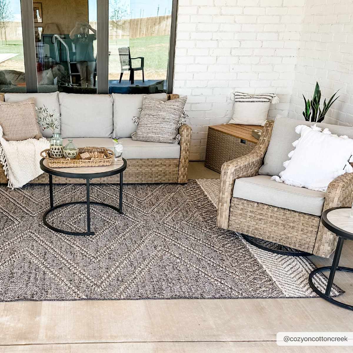Outdoor patio scene with Beige Charcoal Areli Area Rug, wicker furniture, and neutral decor for a cozy, contemporary look. Roomscene-Rectangle