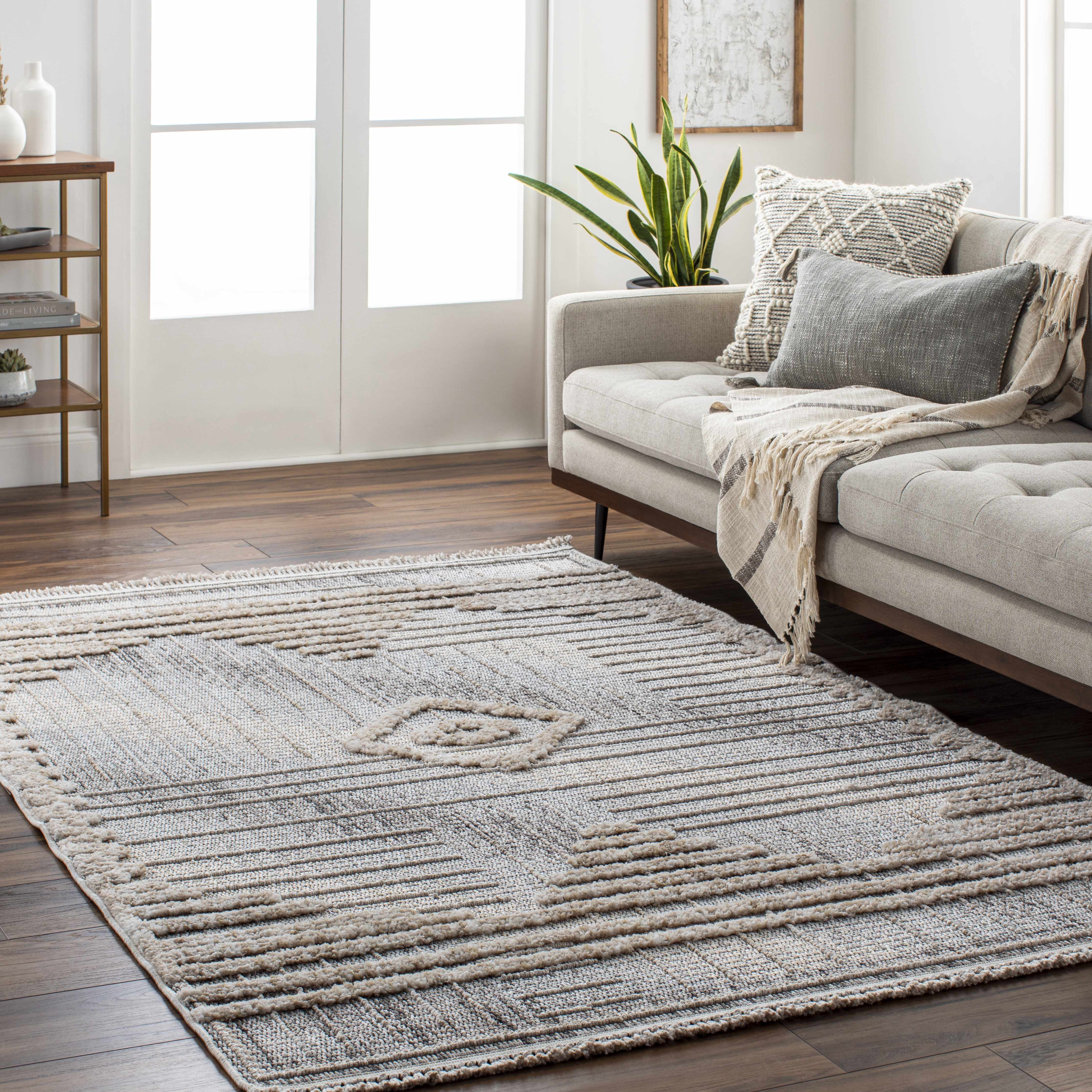 Living room scene with a gray sofa and the geometric Calituban Area Rug on a dark wood floor. Roomscene-Rectangle