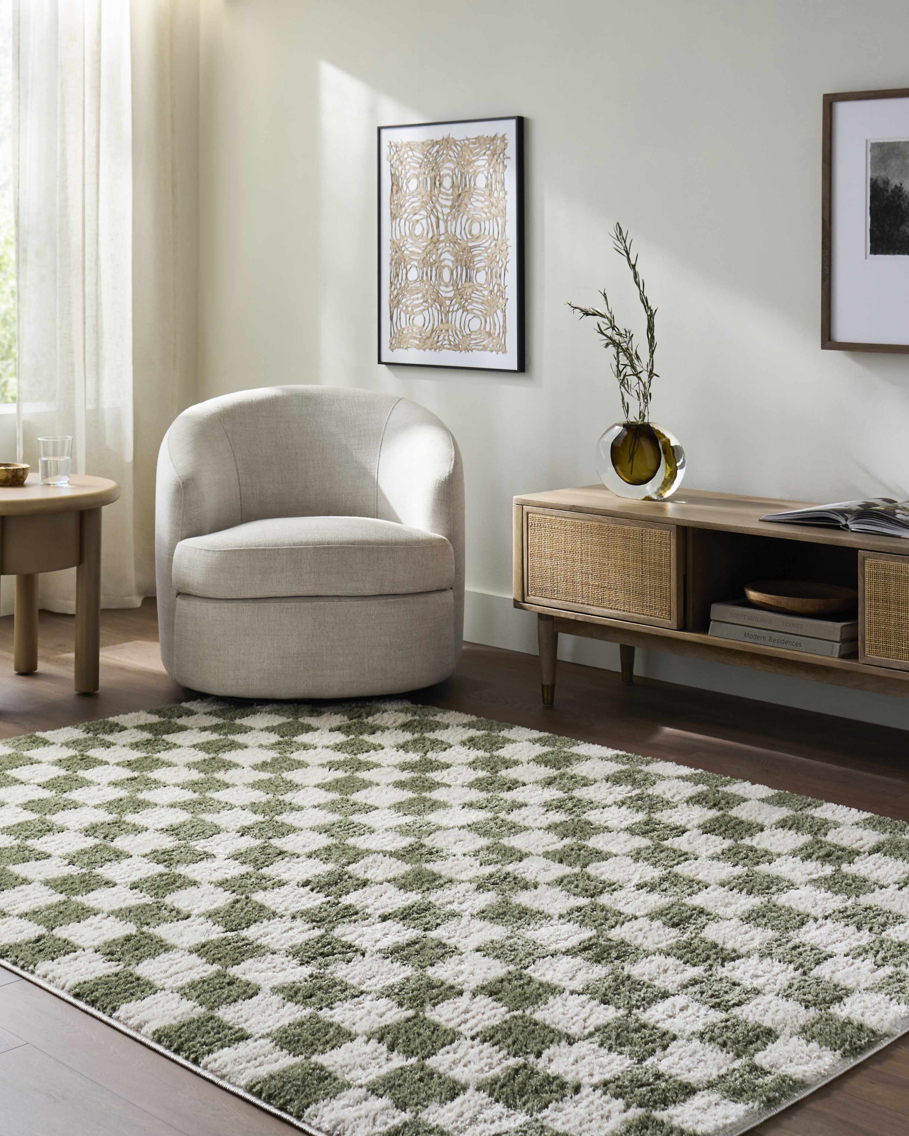 Living room scene with a Canika Green Checkered Washable Plush Rug, neutral chair, wood media console, and light wood floors. Roomscene-Rectangle