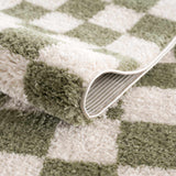 Close-up of the plush Canika Green Checkered Washable Rug, showing the green and off-white checkered pattern. Fold