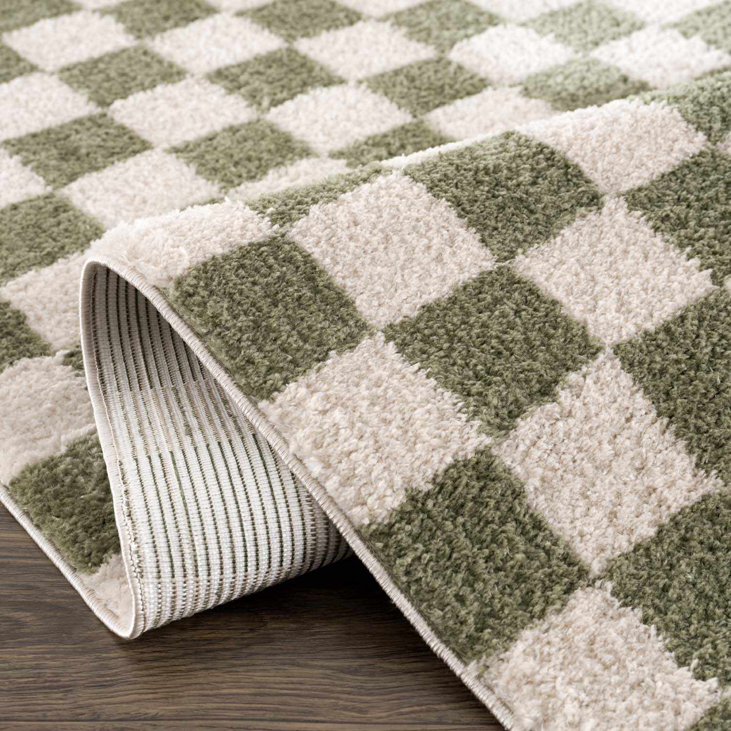 Close-up of a Canika Green Checkered Washable Plush Rug showing its soft texture and green and off-white pattern. Fold