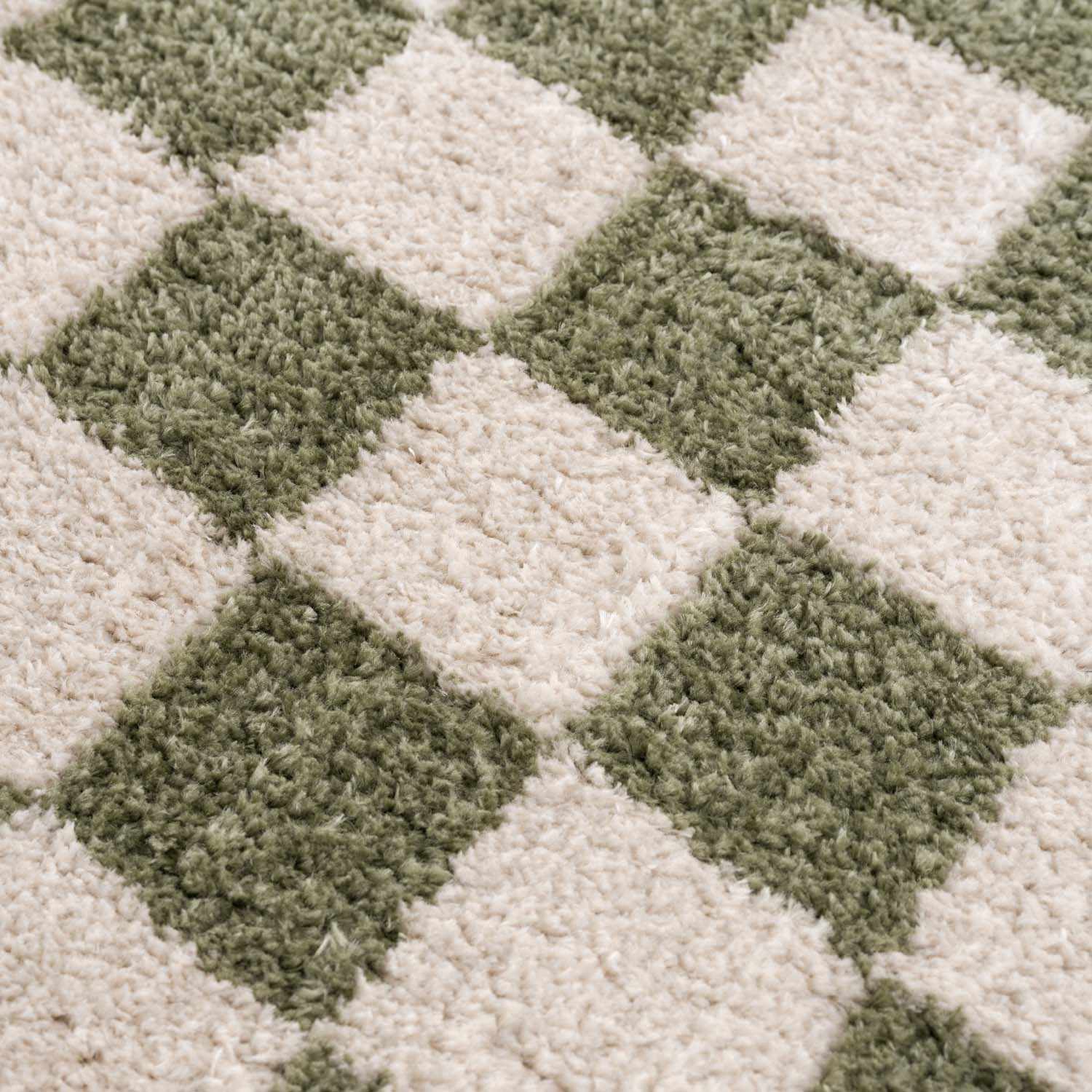 Close-up of the plush Canika Green Checkered Washable Rug. Green and off-white checkered pattern. Texture
