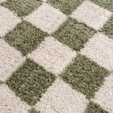 Close-up of the plush Canika Green Checkered Washable Rug. Green and off-white checkered pattern. Texture