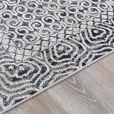 Close-up of the Consuelo Washable Area Rug, featuring a black and gray oriental-inspired pattern on a light gray background. Pile