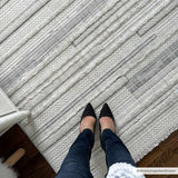 Close-up of the cream and gray striped Dishman Area Rug, showing texture and design detail. Styleshot