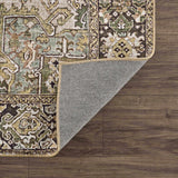 Close-up of the Neyland Sage Green Area Rug showing its oriental pattern, sage, olive, and charcoal colors, and machine-woven texture. Fold