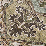 Close-up of the Neyland Sage Green Area Rug showing its traditional olive, charcoal, and cream oriental pattern. Texture