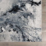 Close-up of the Kirkland Dark Blue Marble Rug. Abstract design in dark blue, black, gray, and beige. Swatch