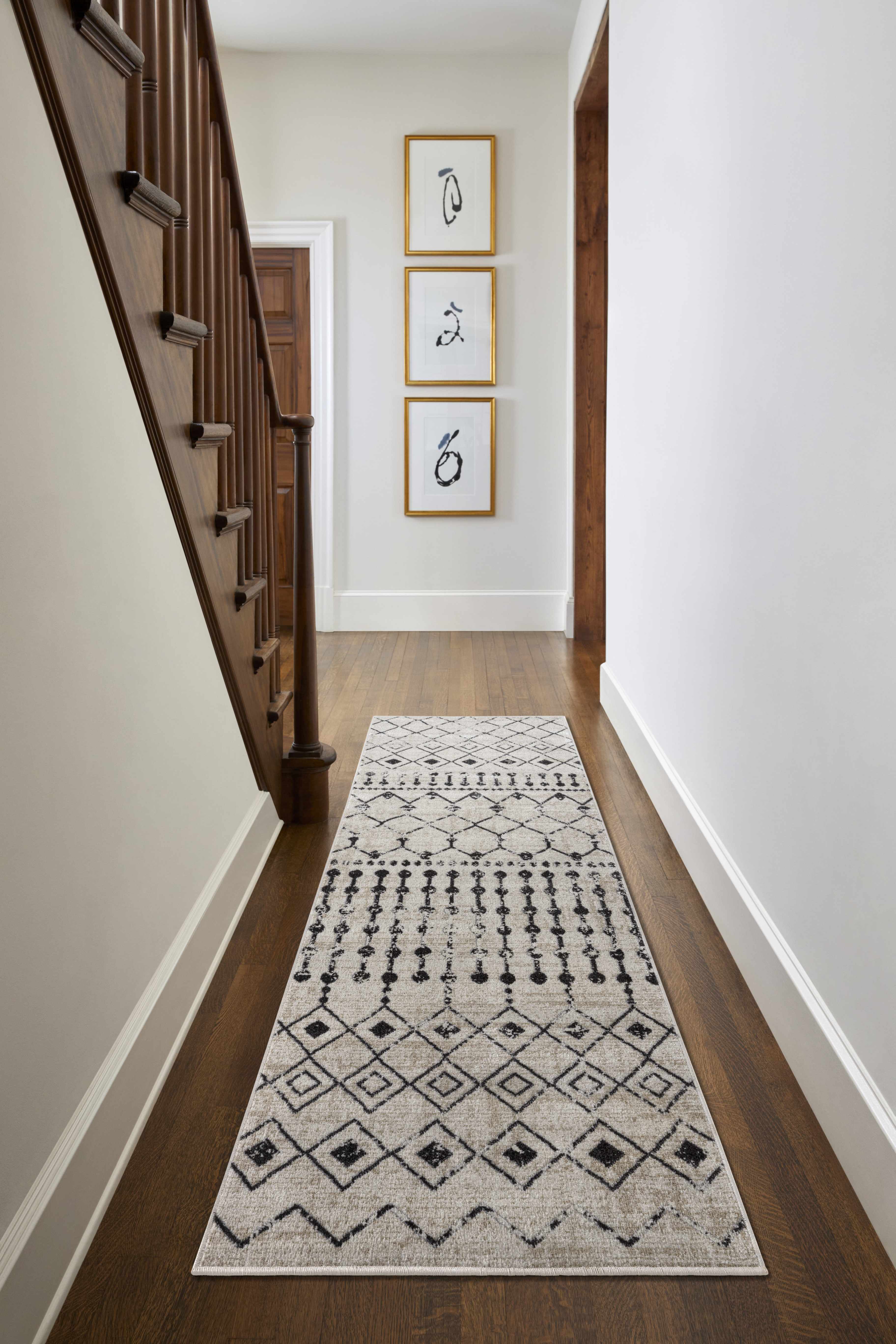 Hallway with wood floors and a black and cream Joppatowne Washable Area Rug runner leading to a staircase. Roomscene-Runner