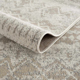 Close-up of Tupsan Washable Area Rug showing its cream, beige, and gray contemporary pattern and machine-woven construction. Fold