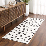 Living room scene with a Tariffville Dalmatian Rug, wood console table, hardwood floors, and white curtains. Roomscene-Runner