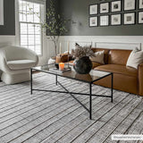 Living room scene with a Naivasha Elegant High/Low Area Rug in charcoal and cream, leather sofa, and glass coffee table. Roomscene-Rectangle
