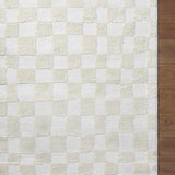 Close-up of the Keesa Checkered Area Rug. Ivory and off-white checkerboard pattern with a plush, textured pile. Corner