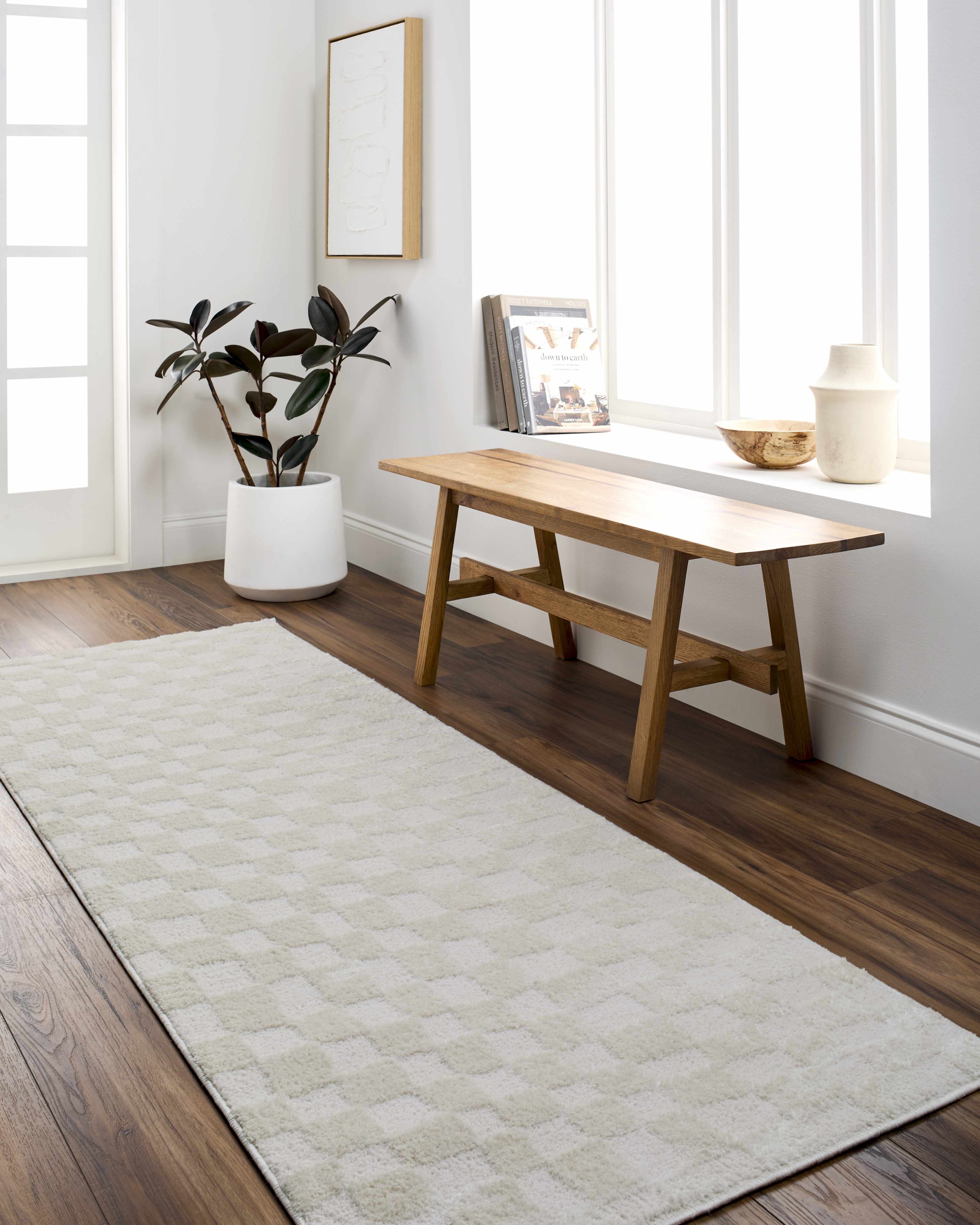 Bright entryway with a Keesa Checkered Area Rug, wood bench, and dark wood floors. Ivory and off-white tones create a serene mood. Roomscene-Runner