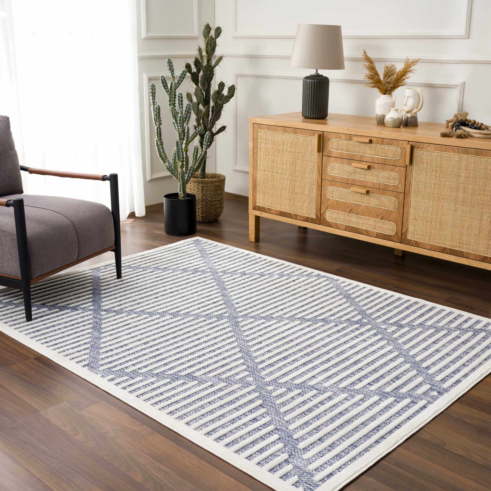 Living room scene with Anah Blue Outdoor Rug, gray chair, and wooden cabinet. Contemporary style. Roomscene-Rectangle