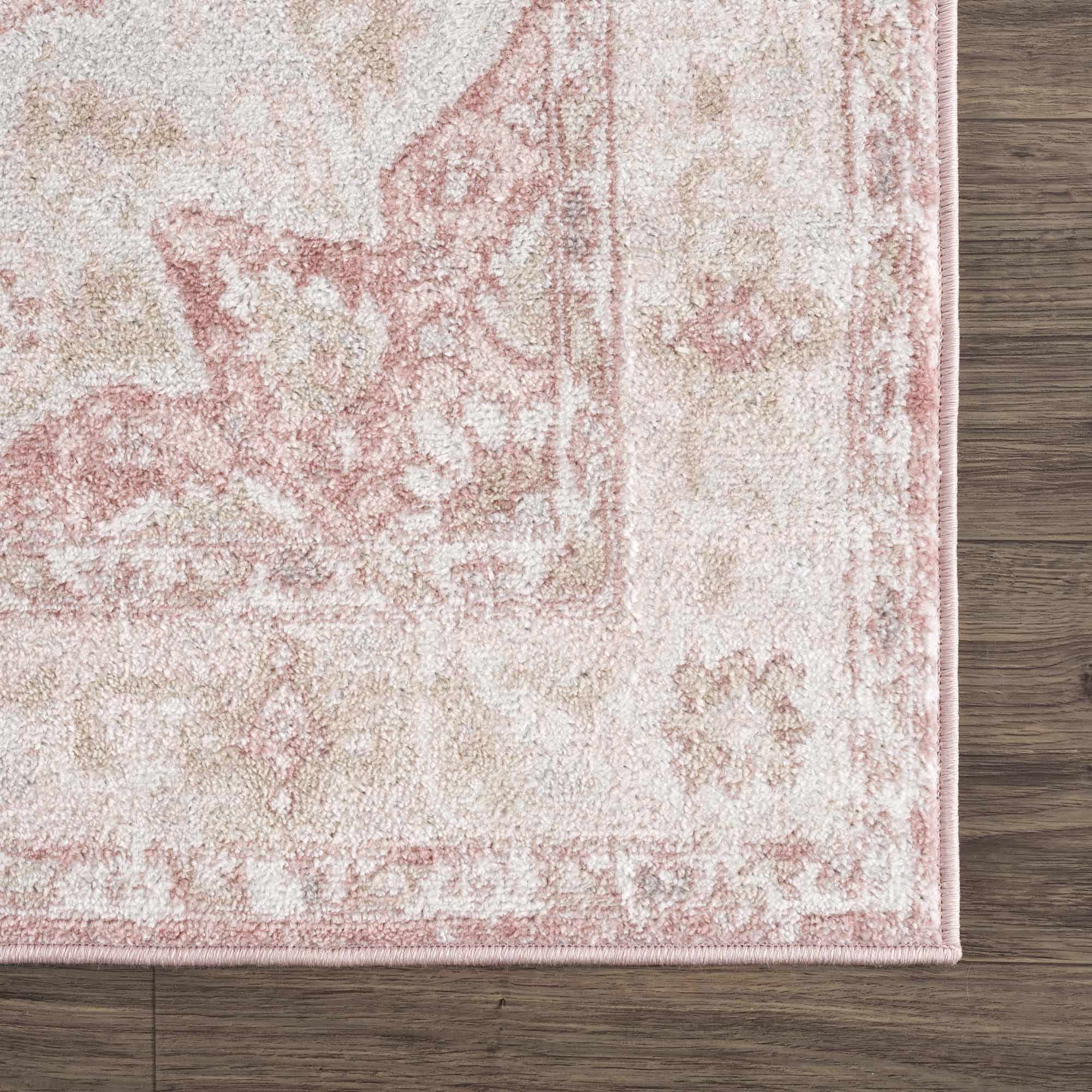 Close-up of the Kandos Blush & Light Pink Area Rug showing its cream, pale pink, and light beige traditional pattern. Corner