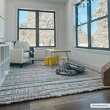 Bright kids room with Silanga area rug, white armchair, small table with yellow stools, and large windows. Roomscene-Rectangle