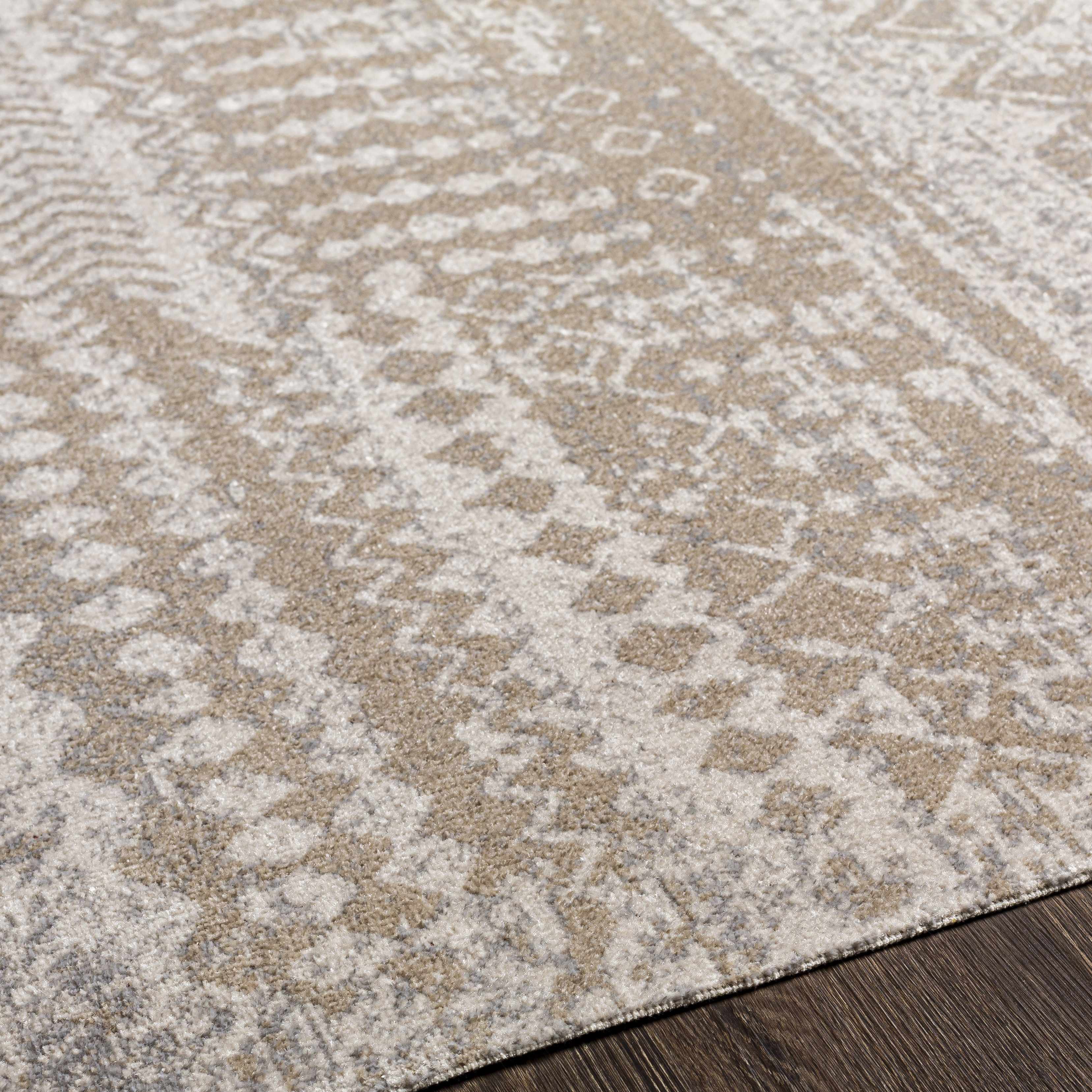 Close-up of the Tupsan Washable Area Rug. Cream, light beige, and gray rug with a subtle, contemporary pattern. Texture