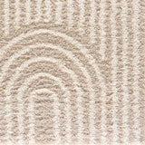 Close-up of the Emmly Shag Area Rug, featuring a geometric pattern in gray, light peach, nutmeg, smoke, and white thatch. Texture