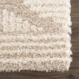 Close-up of the Igor Shag Area Rug. Shaggy texture in light peach, mocha, and nutmeg tones on a dark wood floor. Swatch