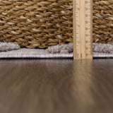 Close-up of the Borbon Area Rug showing its pile height with a ruler and a woven basket in the background. Pile