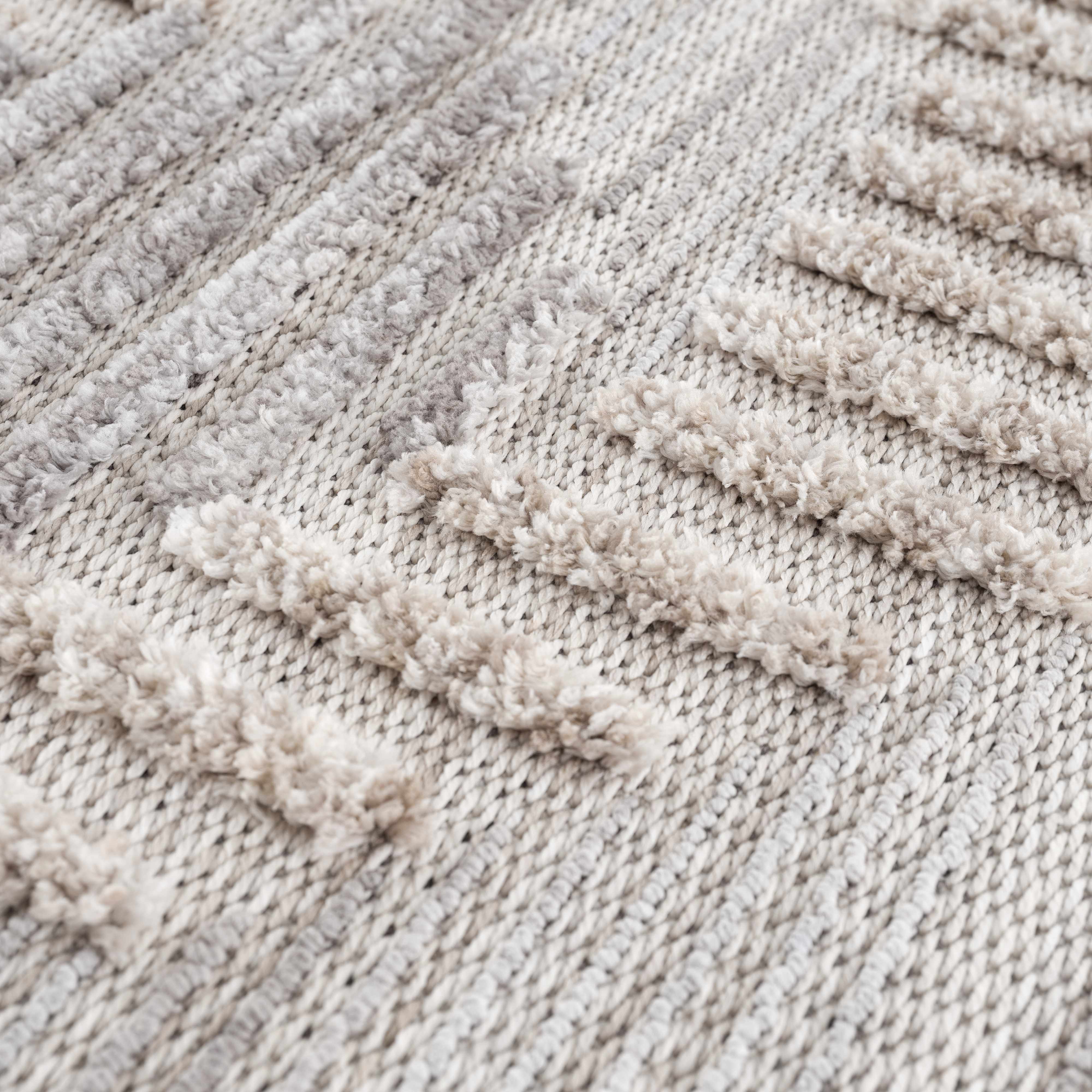 Close-up of the Muricay High-Low Rustic Rug, showing its textured, geometric design in cream, beige, and gray polyester. Texture