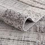 Close-up of Naivasha Elegant High/Low Area Rug. Charcoal, cream, and gray textured rug with a high-low pile design. Fold