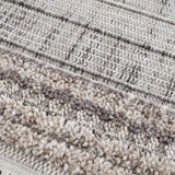 Close-up of the Naivasha Elegant High/Low Area Rug. Features charcoal, cream, and gray tones with a textured, high-low pile. Texture