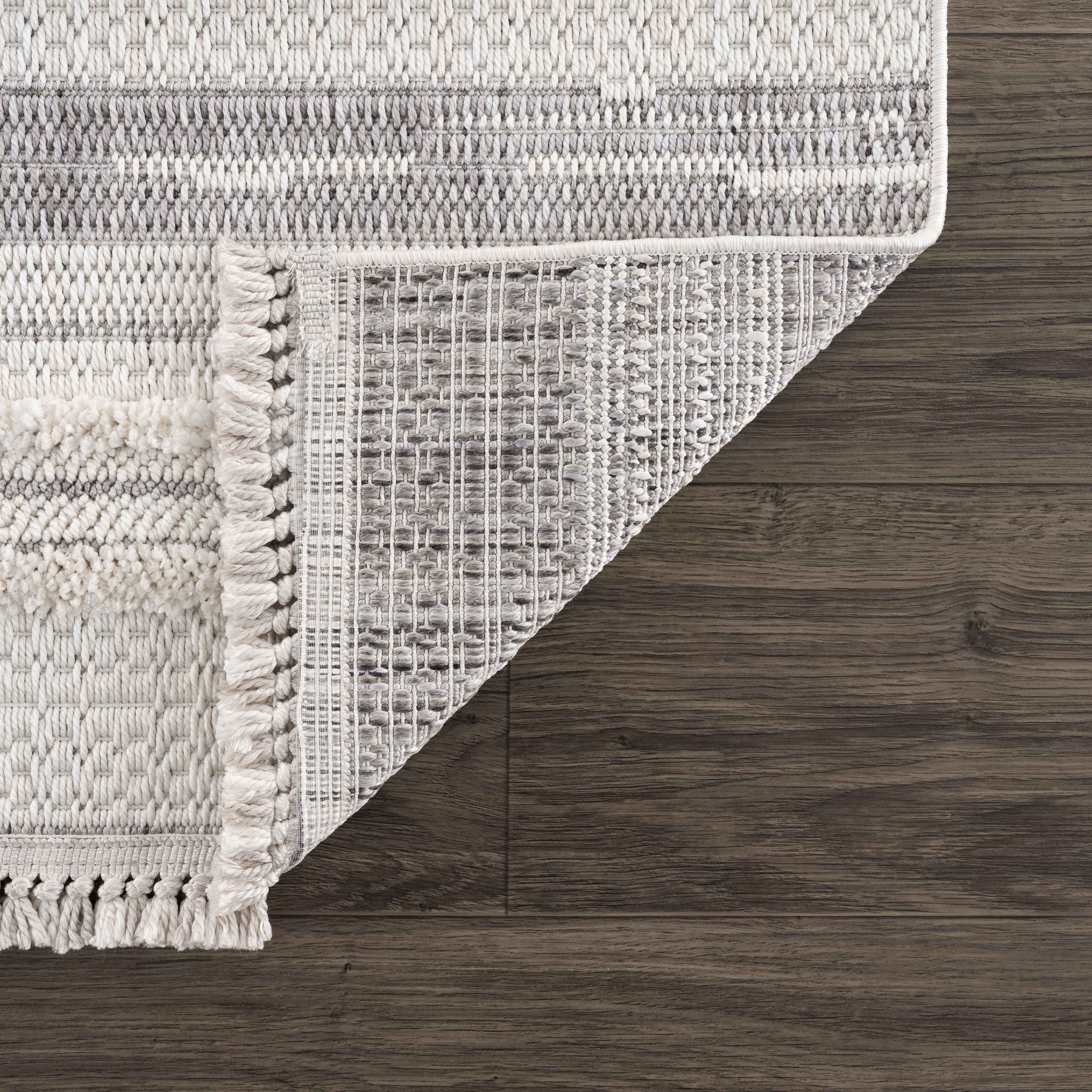 Close-up of the cream and light gray Dishman Area Rug showing the striped geometric pattern and woven texture. Fold