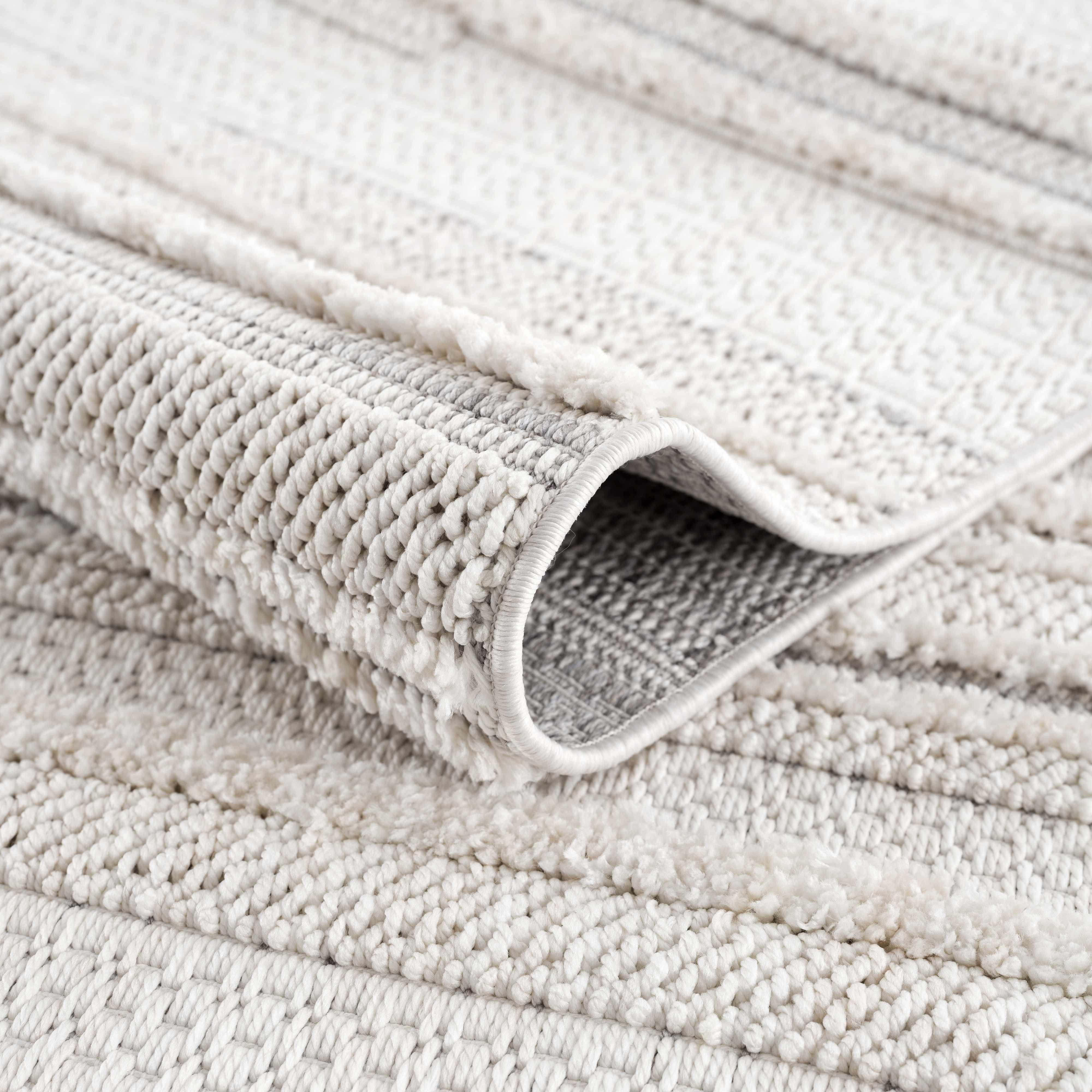 Close up of the cream and light gray Dishman Area Rug showing texture and striped geometric pattern. Fold