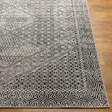 Close-up of the Consuelo Washable Area Rug. Black, gray, and light gray geometric patterns on a polyester rug. Front