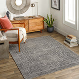 Living room scene with gray Consuelo Washable Area Rug, wood floors, mid-century modern furniture, and neutral decor. Roomscene-Rectangle