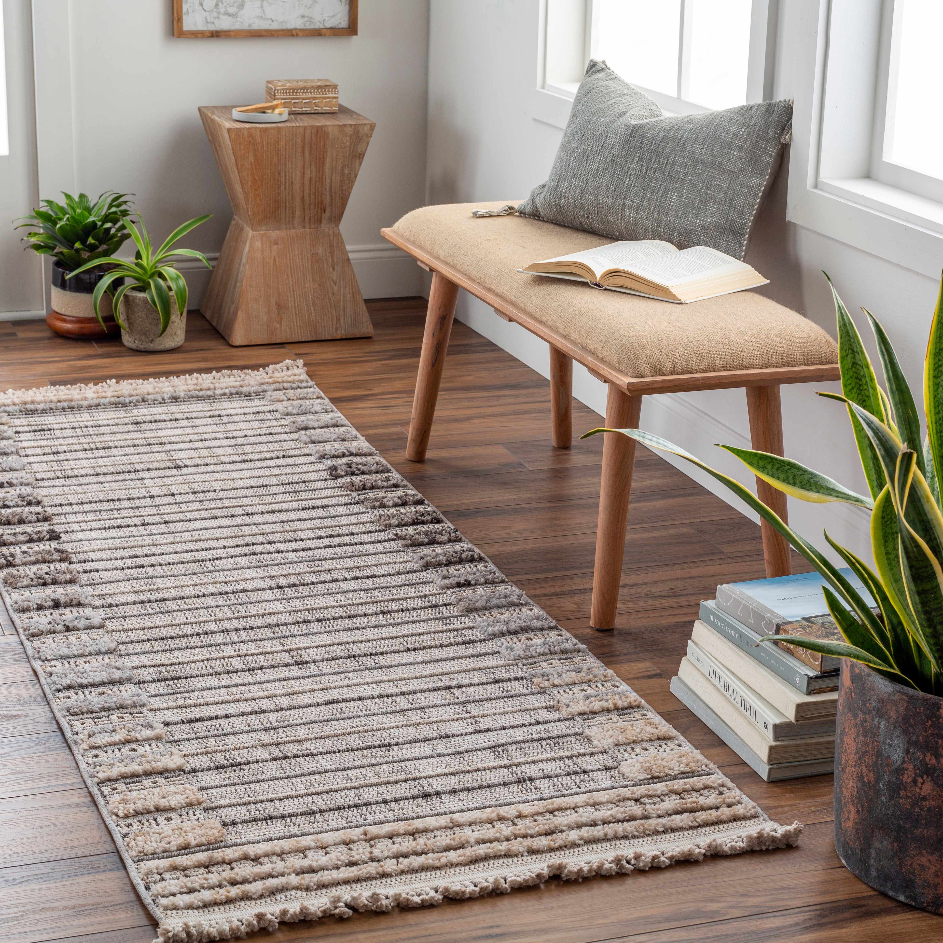 Entryway with Naivasha Elegant rug in charcoal and cream, wood bench, plants, and books for a cozy, Scandinavian feel. Roomscene-Rectangle