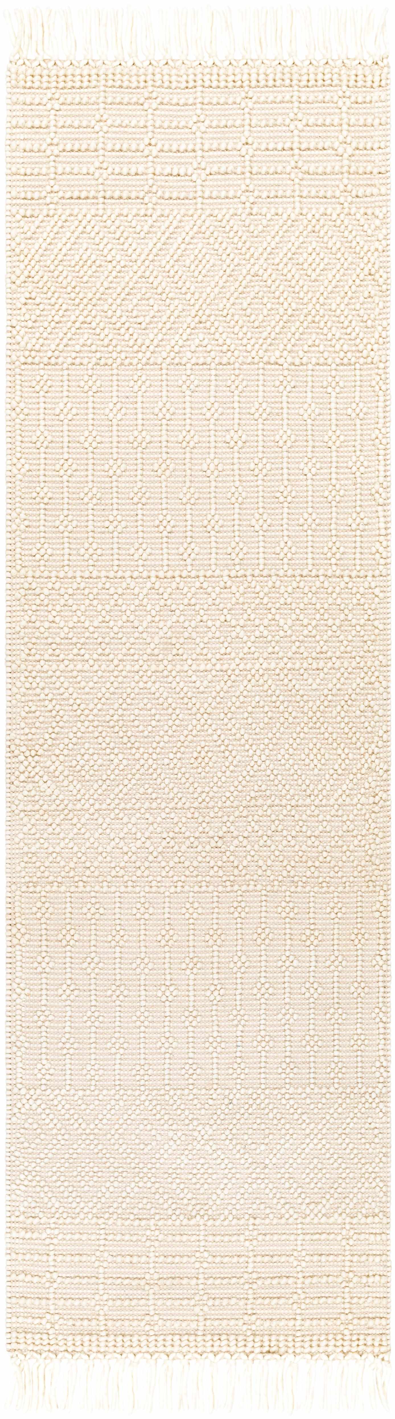 Close-up of the Ryne Area Rug in white thatch. Hand-woven rug with geometric patterns and fringe. Bohemian, farmhouse style. Design-Runner-268