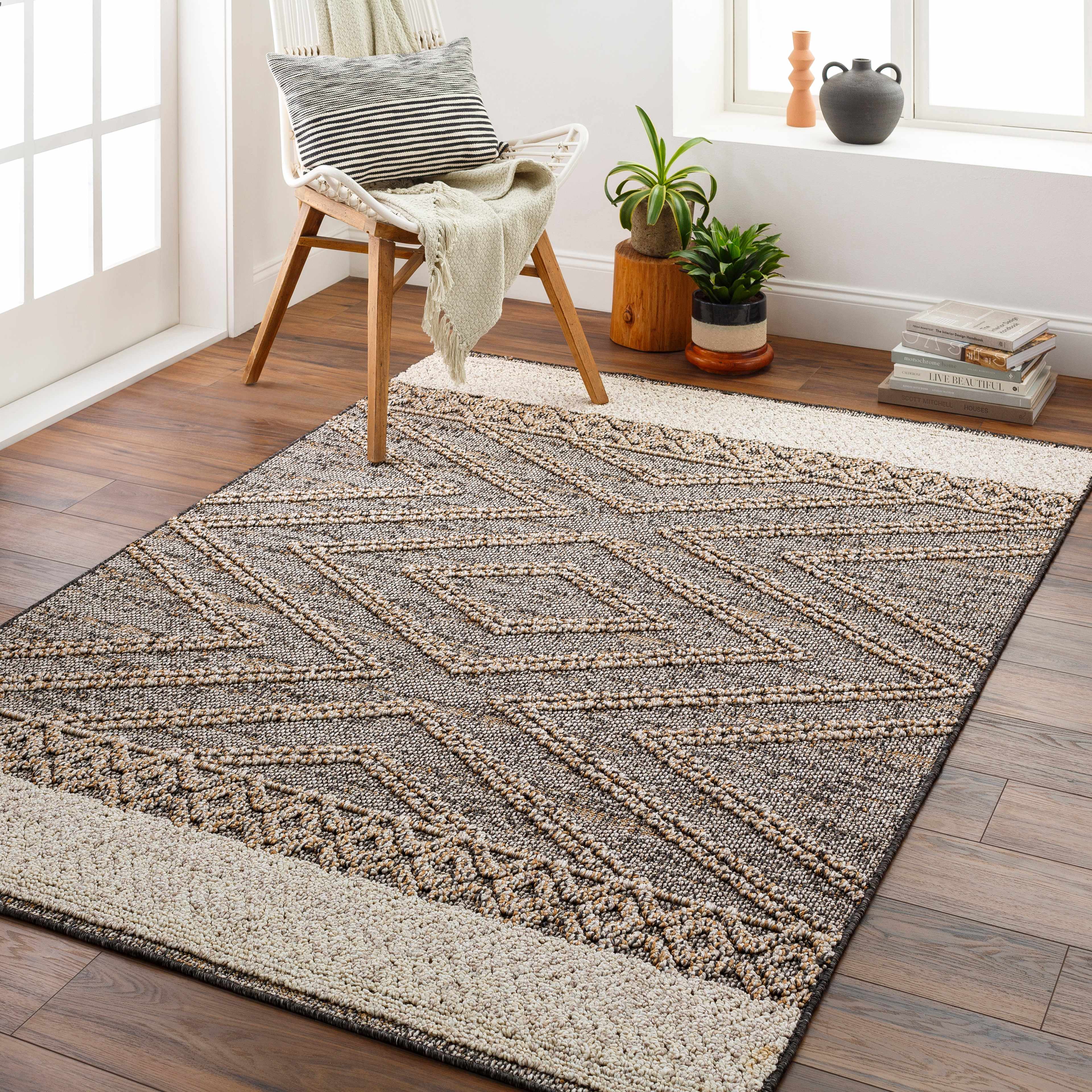 Living room scene with Beige Charcoal Areli Area Rug, wood floors, chair, plants, and natural light. Roomscene-Rectangle