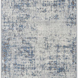 Close-up of the Texanna Abstract Blue/Gray Area Rug. Features an abstract pattern in gray, light blue, and off-white tones. Design-Runner-2710