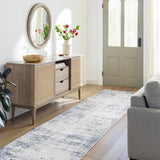 Entryway with a Texanna Abstract Blue/Gray Area Rug runner, wood floors, console table, mirror, and gray sofa. Roomscene-Runner