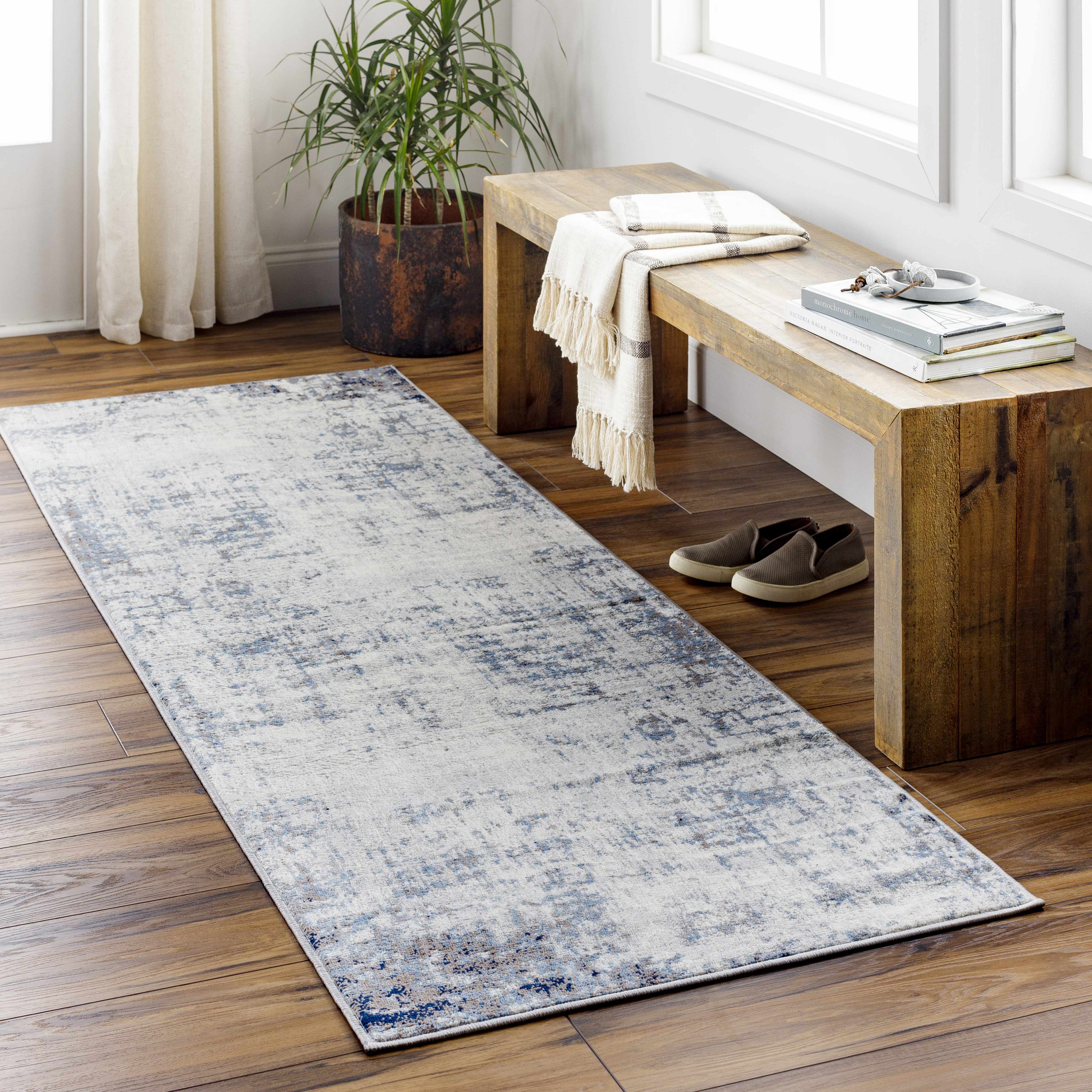 Entryway with wood floors and Texanna Abstract Blue/Gray Area Rug. Rustic bench, plant and natural light. Roomscene-Runner